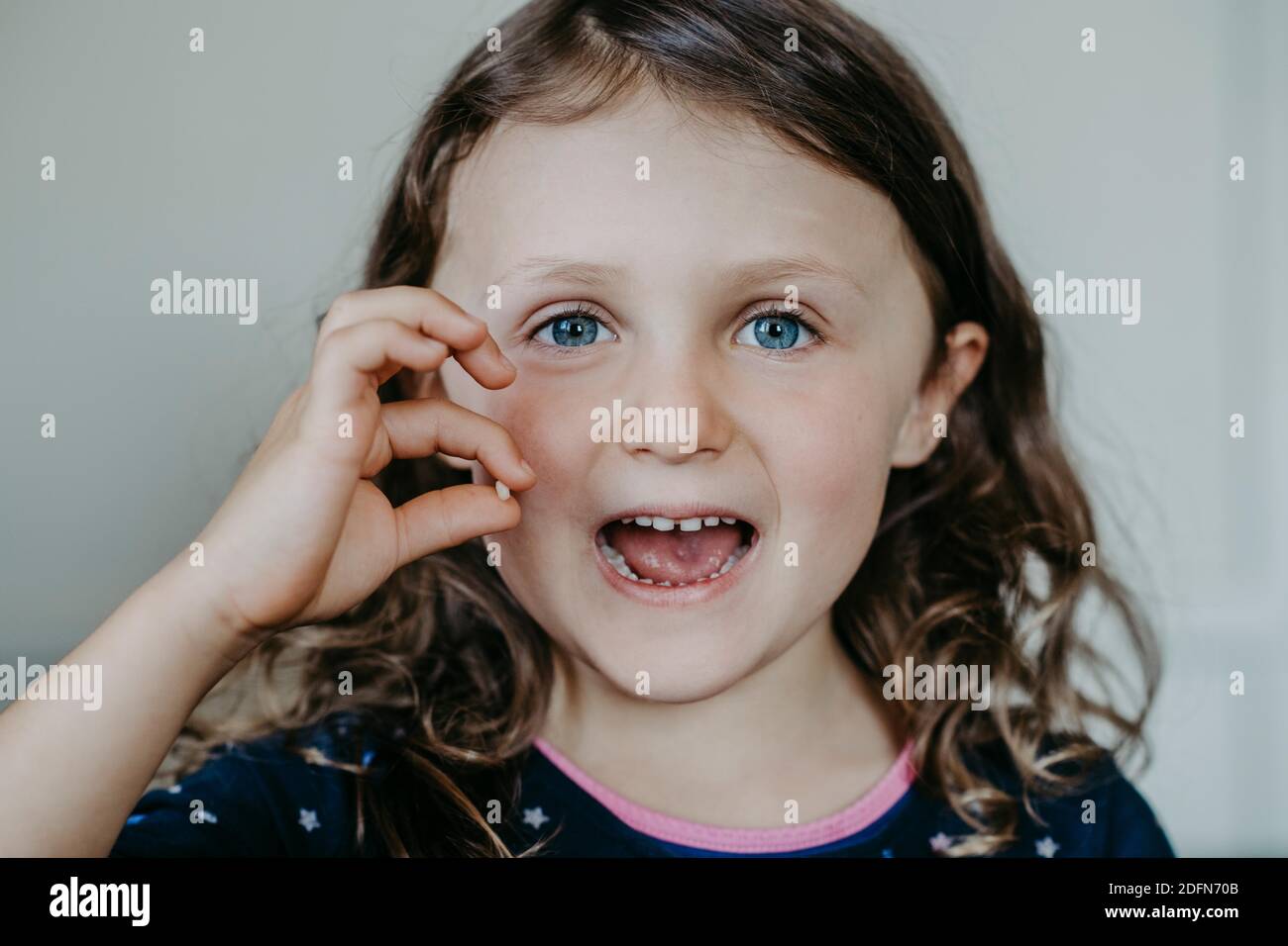 Mädchen mit Lücke und gefallenen Zahn in der Hand Stockfoto