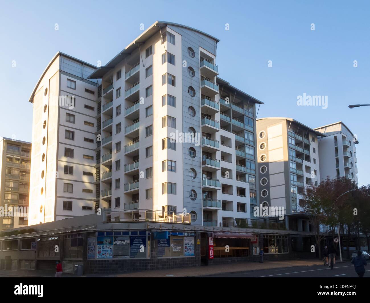 Apartmentblock in moderner oder zeitgenössischer Architektur, gelegen über Geschäften in einem städtischen Vorort von Kapstadt, Südafrika Stockfoto