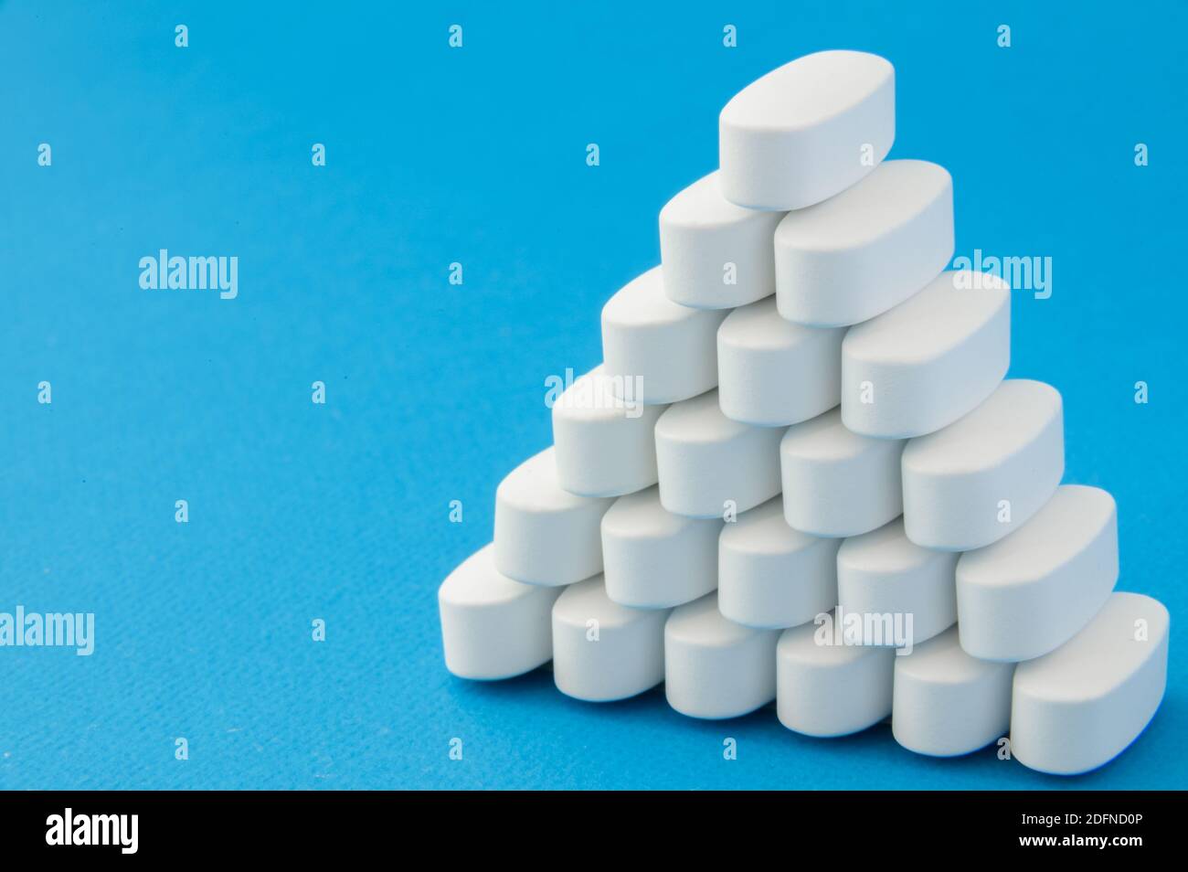 Viele weiße Tabletten Pillen auf blauer Oberfläche Stockfoto