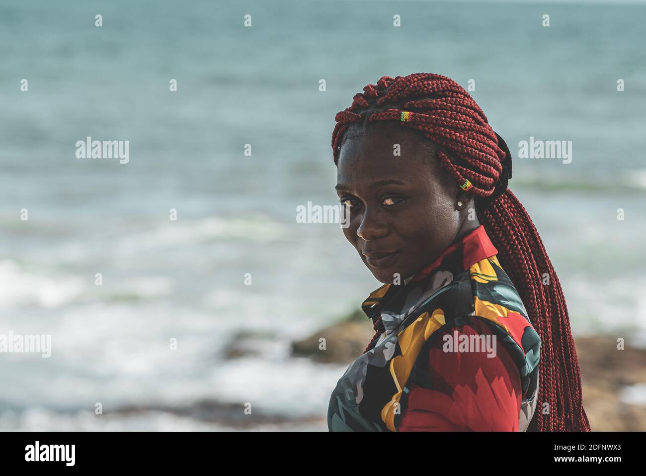 Afrikanische Frau mit Rasta-Haar mit kleinen ghana-Fahnen angebracht An der Accra Küste Ghana Stockfoto
