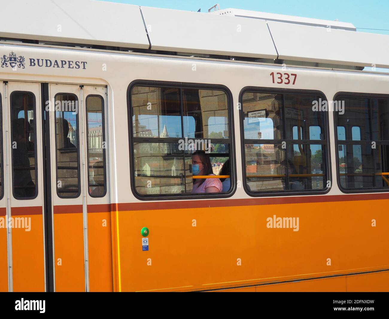 Budapest, Ungarn - 21. September 2020: Frau in Maske wegen Coronavirus-Einschränkungen Tarvel auf der traditionellen gelben Straßenbahn in der Innenstadt Stockfoto