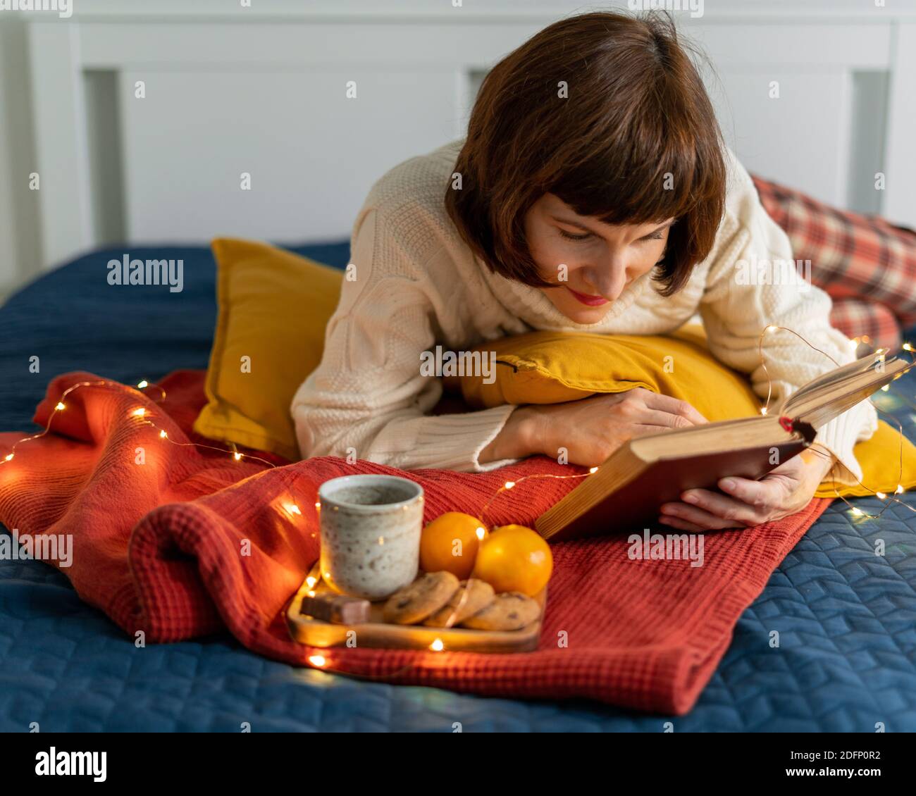 Schöne reife Frau Buch lesen. Gemütlicher Hintergrund zum Entspannen und Besinnen. Stockfoto
