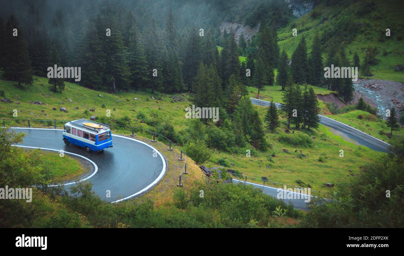 Alte Reisebuswagen auf einer Serpentinen Straße in der schweiz moody regnerischen Tag Stockfoto