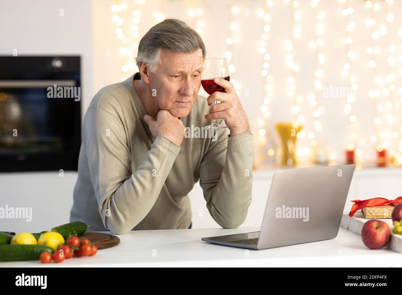 Einsamer Älterer Mann Feiert Weihnachten Allein Bei Laptop In Der Küche Stockfoto