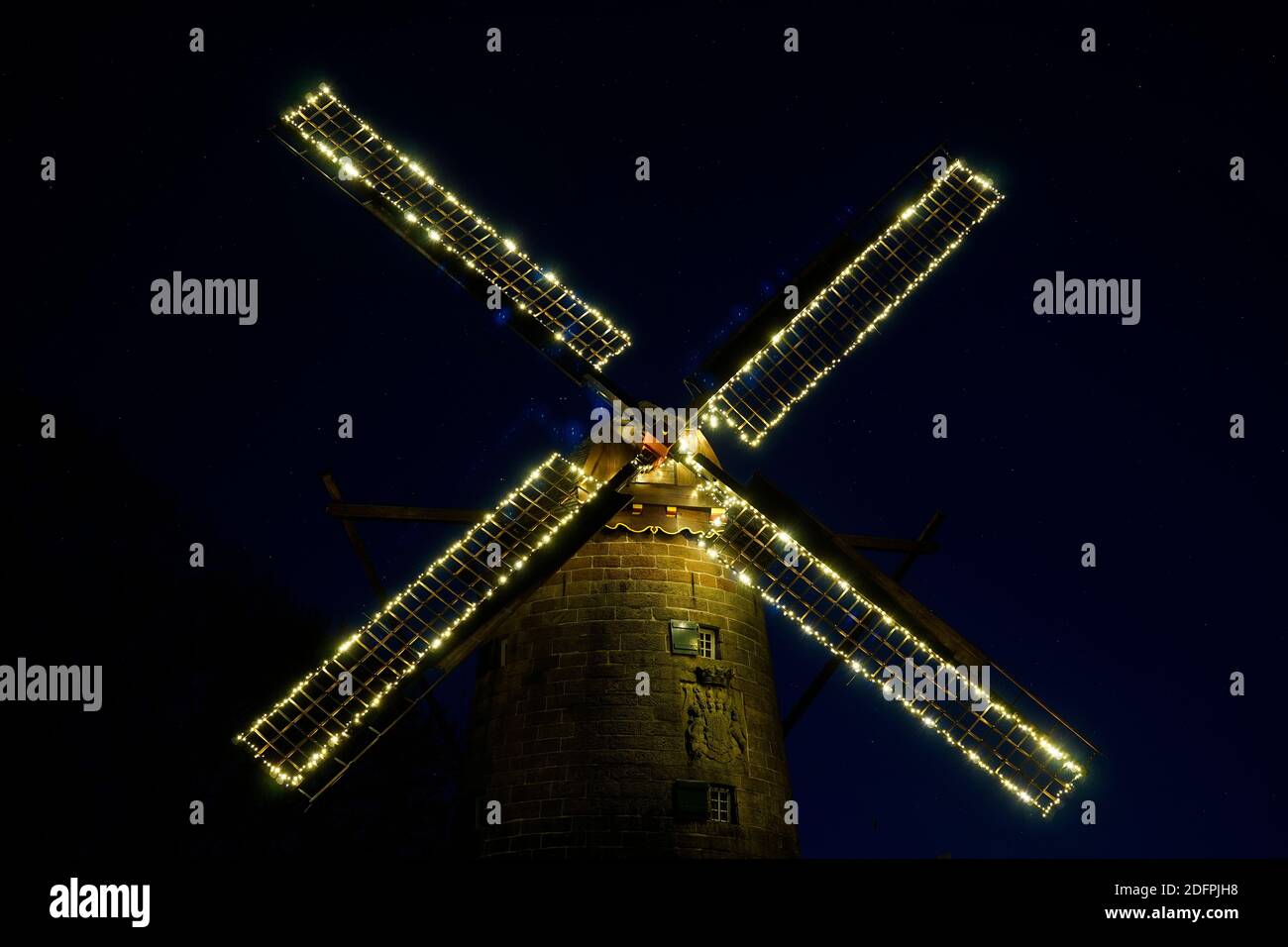 Die alte holländische Windmühle in der Nacht. Die Flügel sind beleuchtet. Sterne am Himmel. Diese Mühle wurde zur Herstellung von Mehl verwendet Stockfoto