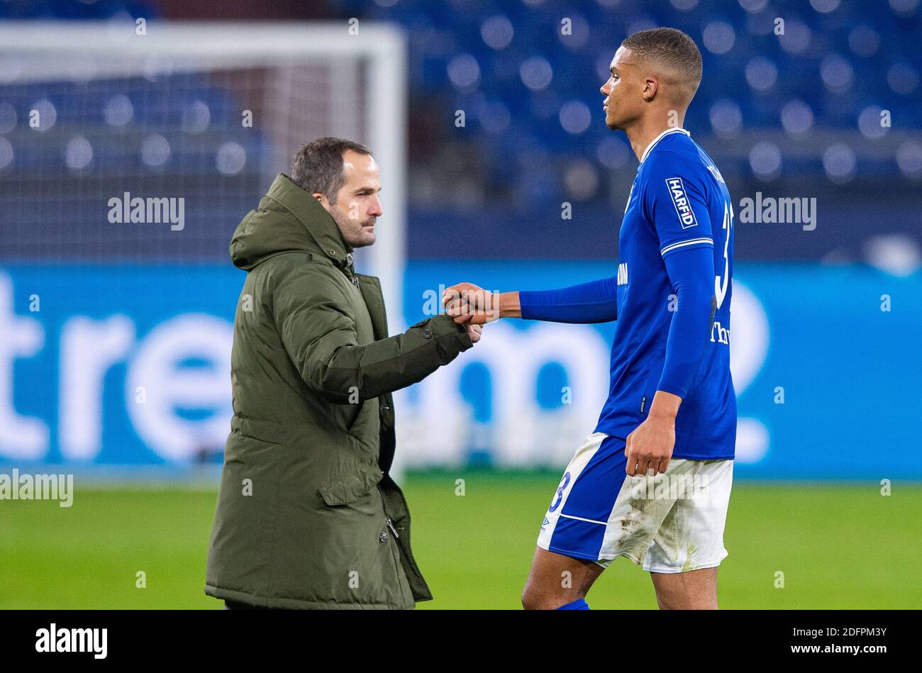 Gelsenkirchen, Deutschland. Dezember 2020. Fußball: Bundesliga, FC Schalke 04 - Bayer Leverkusen, 10. Spieltag in der Veltins Arena. Schalkes Malick Thiaw (r) klatscht sich nach dem Spiel mit Schalkes Trainer Manuel Baum in die Hände. Quelle: Guido Kirchner/dpa - WICHTIGER HINWEIS: Gemäß den Bestimmungen der DFL Deutsche Fußball Liga und des DFB Deutscher Fußball-Bund ist es untersagt, im Stadion und/oder aus dem Spiel aufgenommene Aufnahmen in Form von Sequenzbildern und/oder videoähnlichen Fotoserien zu nutzen oder auszunutzen./dpa/Alamy Live News Stockfoto