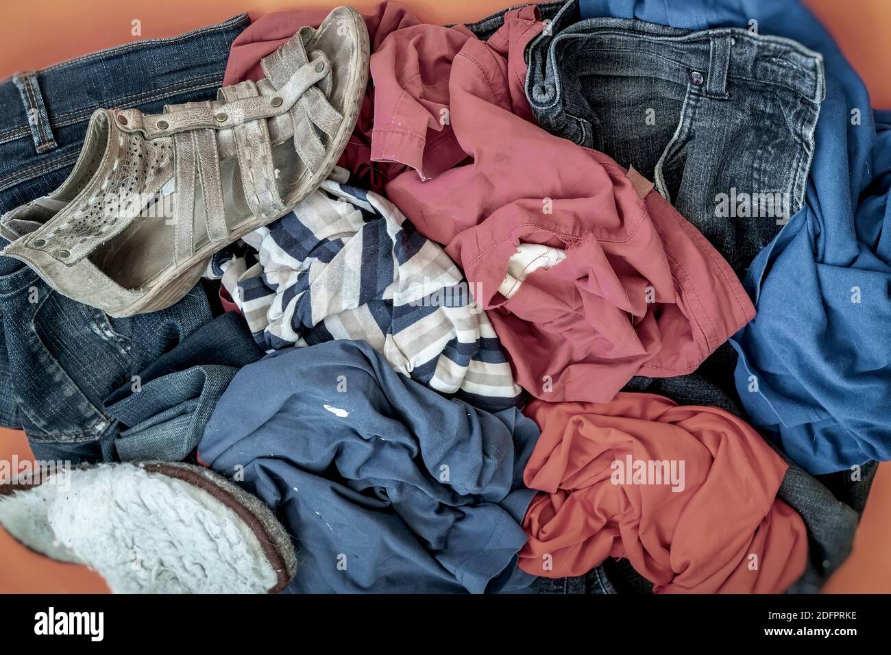 Stapel von alten schmutzigen Kleidern und Schuhen zur Entsorgung. Blick von oben. Recycling-Verarbeitung, recyclingfähige Materialien Konzept Stockfoto