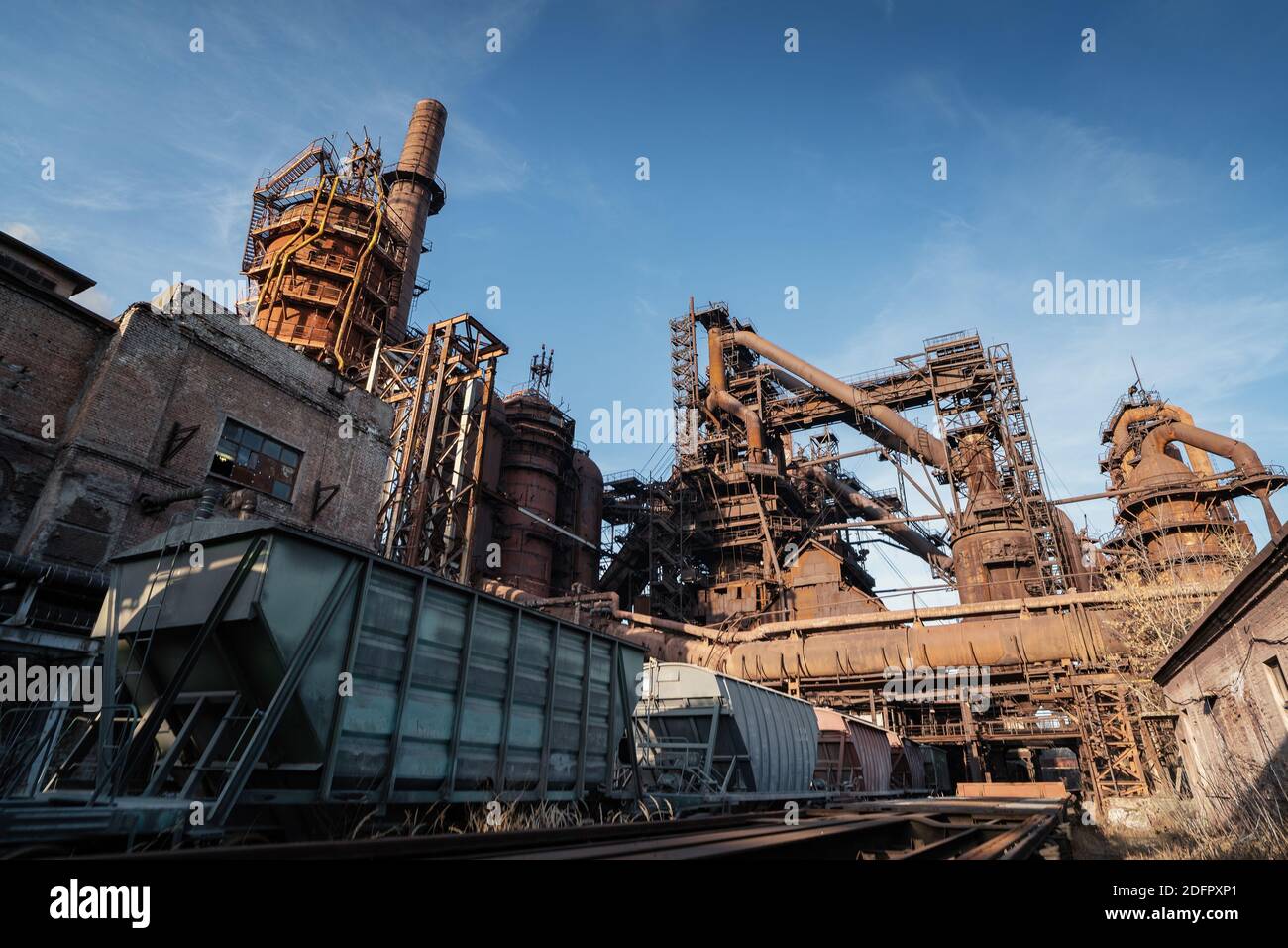 Hochofen von metallurgischen Anlagen oder Chemiefabrik mit industriellen Eisenbahn- und Güterwagen. Stockfoto