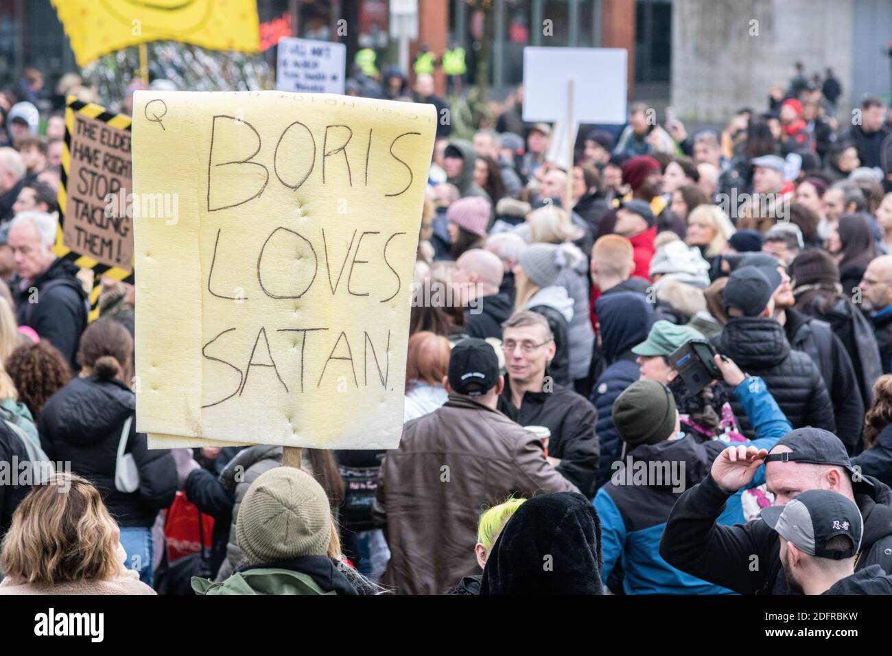 Manchester Piccadilly Gardens 6. Dez 2020: Anti Lockdown/Anti Tier System Protest. Eine Person hält ein Plakat mit der Aufschrift Boris liebt Satan hoch Stockfoto