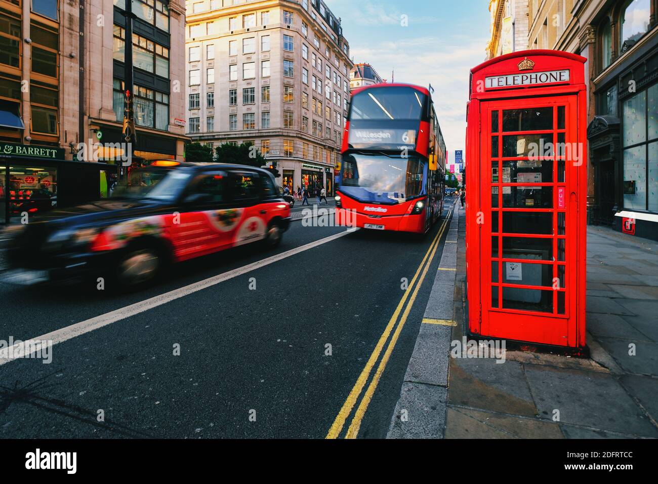 Ikonen von London. Schwarzes Taxi, roter Doppeldeckerbus und Telefonkabine am Strand, einer berühmten London Street Stockfoto