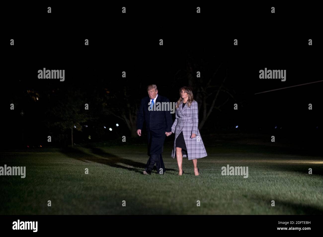 10/30/18, das Weiße Haus, Washington, D.C. US-Präsident Donald Trump, links, geht mit US-First Lady Melania Trump auf dem South Lawn des Weißen Hauses nach der Ankunft auf Marine One in Washington, D.C., USA, am Dienstag, 30. Oktober 2018. Die vier Spitzenpolitiker im Kongress lehnten Trumps Einladung ab, sich ihm am Dienstag auf eine Reise nach Pittsburgh zu begleiten, um Beileid für den Angriff auf eine Synagoge zu bekunden, bei dem ein Schütze 11 Menschen tötete. Fotografin: Gabriella Demczuk/Bloomberg Stockfoto