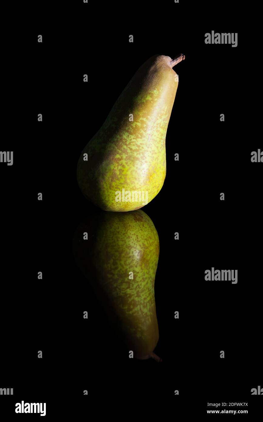 Low-Key-Foto einer einzelnen Birne gegen eine schwarze Hintergrund Stockfoto