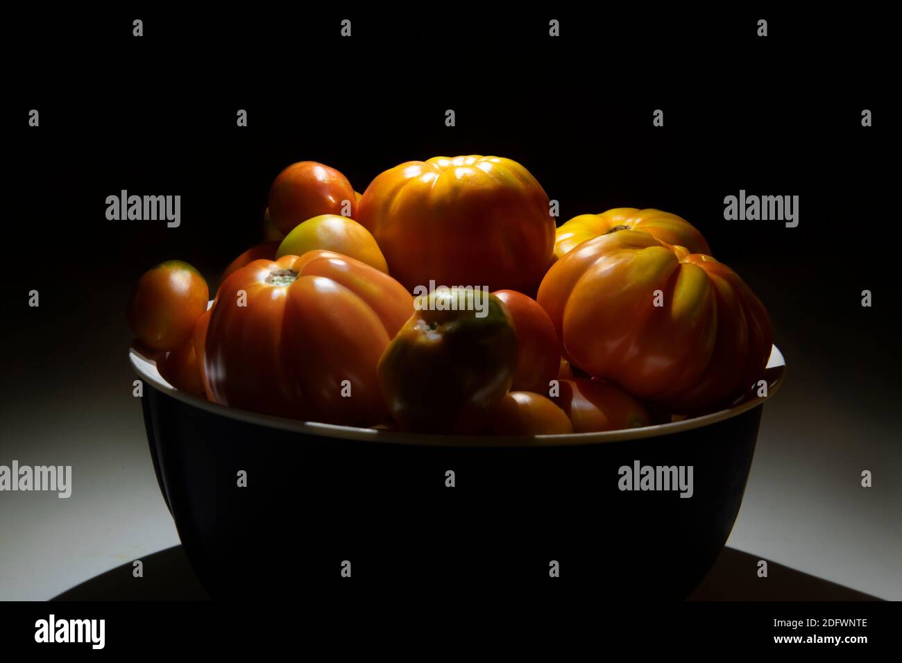 Low-Key-Foto von verschiedenen Arten von frischen Tomaten in Eine Schüssel Stockfoto