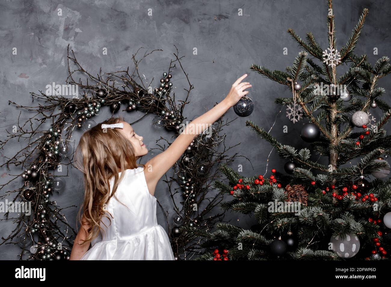 Kind Tochter schmücken Weihnachtsbaum zu Hause. Vorbereitung nach Hause für Silvester Party, Familie genießen Winterurlaub. Familien-, Winterurlaub Konzept Stockfoto