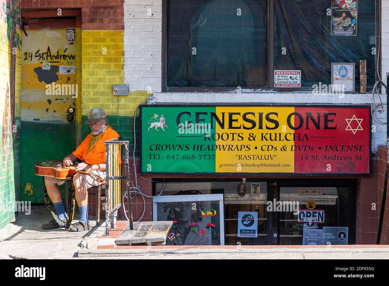 Kensington Market in Toronto, Kanada. Senior Mann Tuning einer akustischen Gitarre Stockfoto