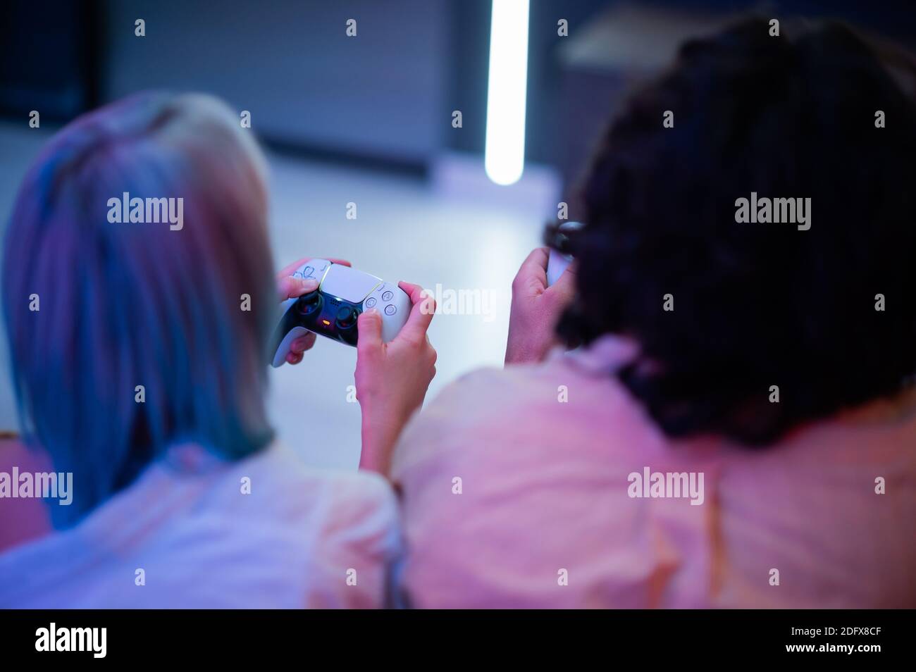 Hübscher junger Mann beizubringen, wie man die Videospiele zu seiner Freundin auf der Couch, Konzept über home-Entertainment, Videospiele zu spielen. Stockfoto