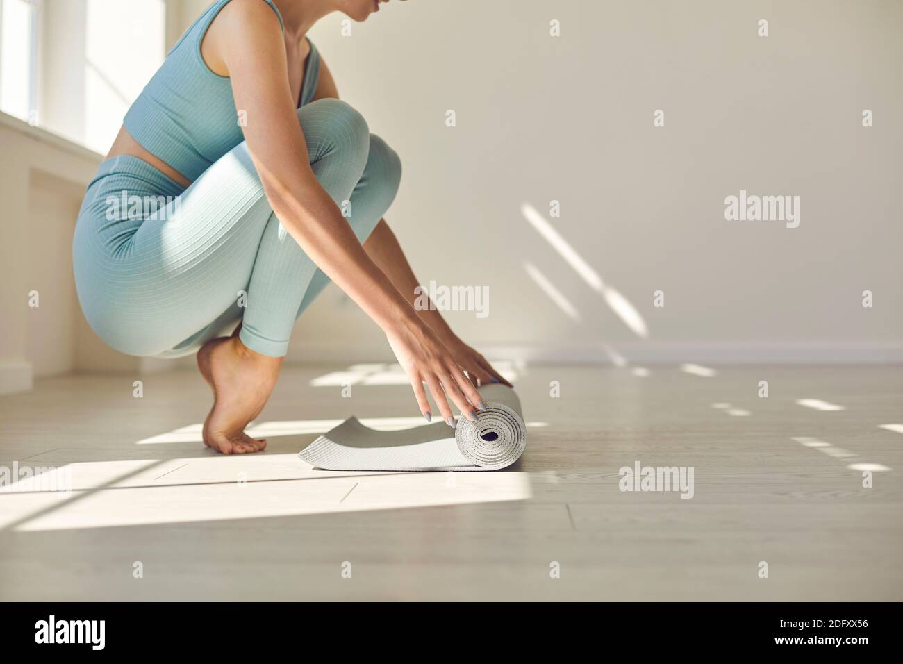 Mädchen barfuß sitzen und Vorbereitung Fitness-Teppich für das Training oder Yoga Stockfoto
