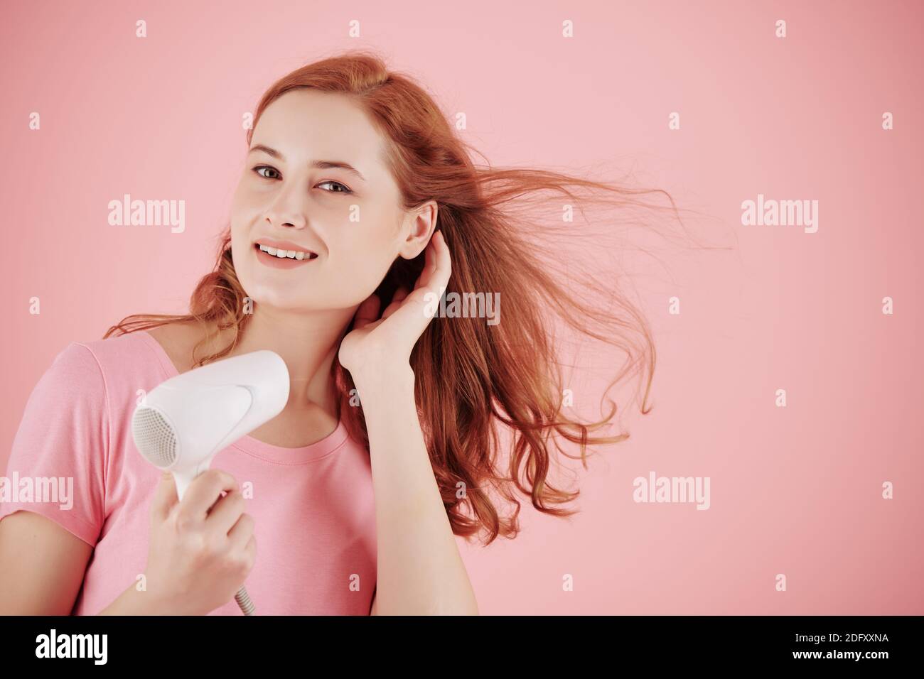 Frau bläst die Haare aus Stockfoto