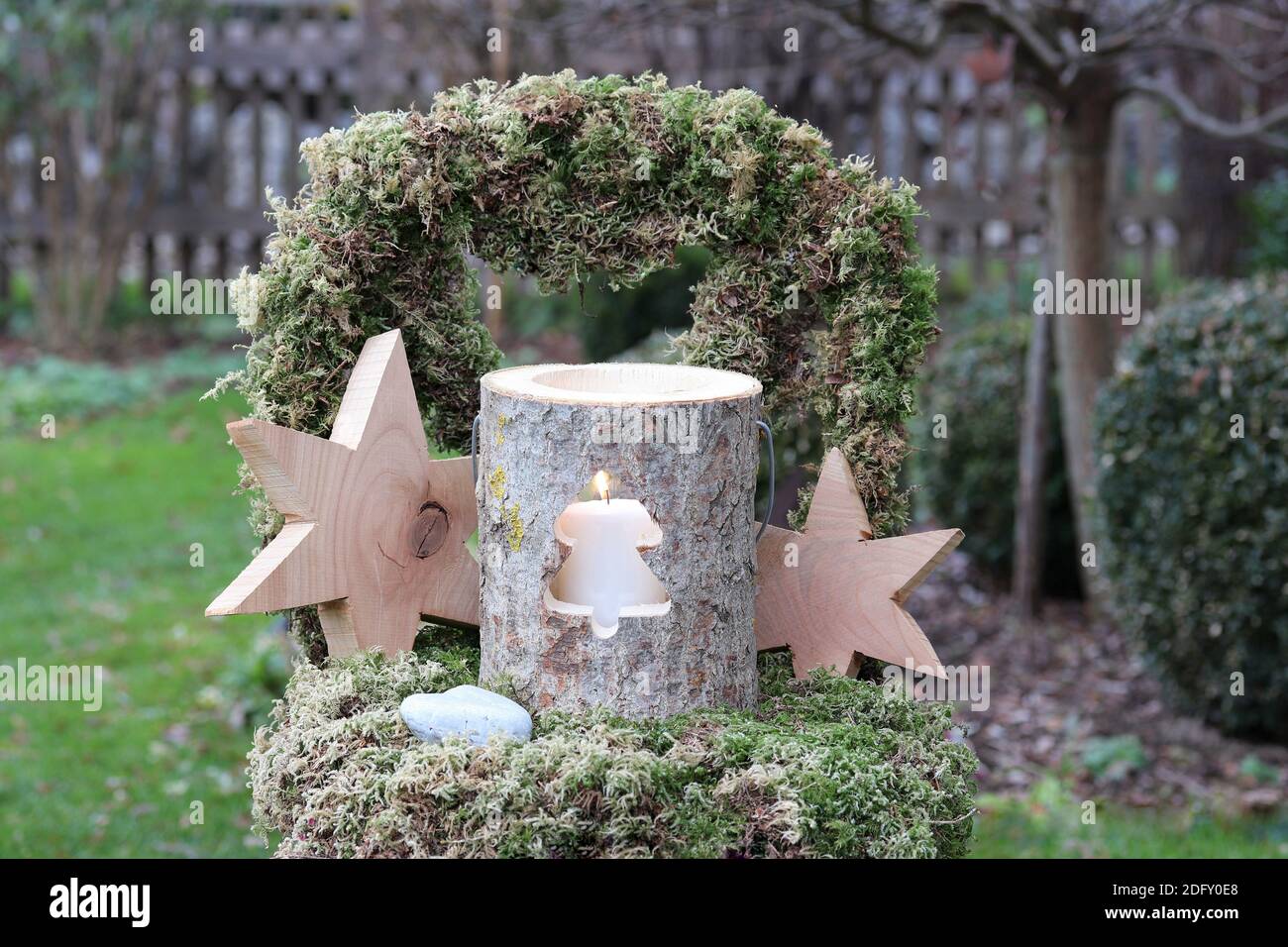 weihnachtliche Gartendekoration mit Holzlaterne und Sternen auf Moos Stuhl Stockfoto