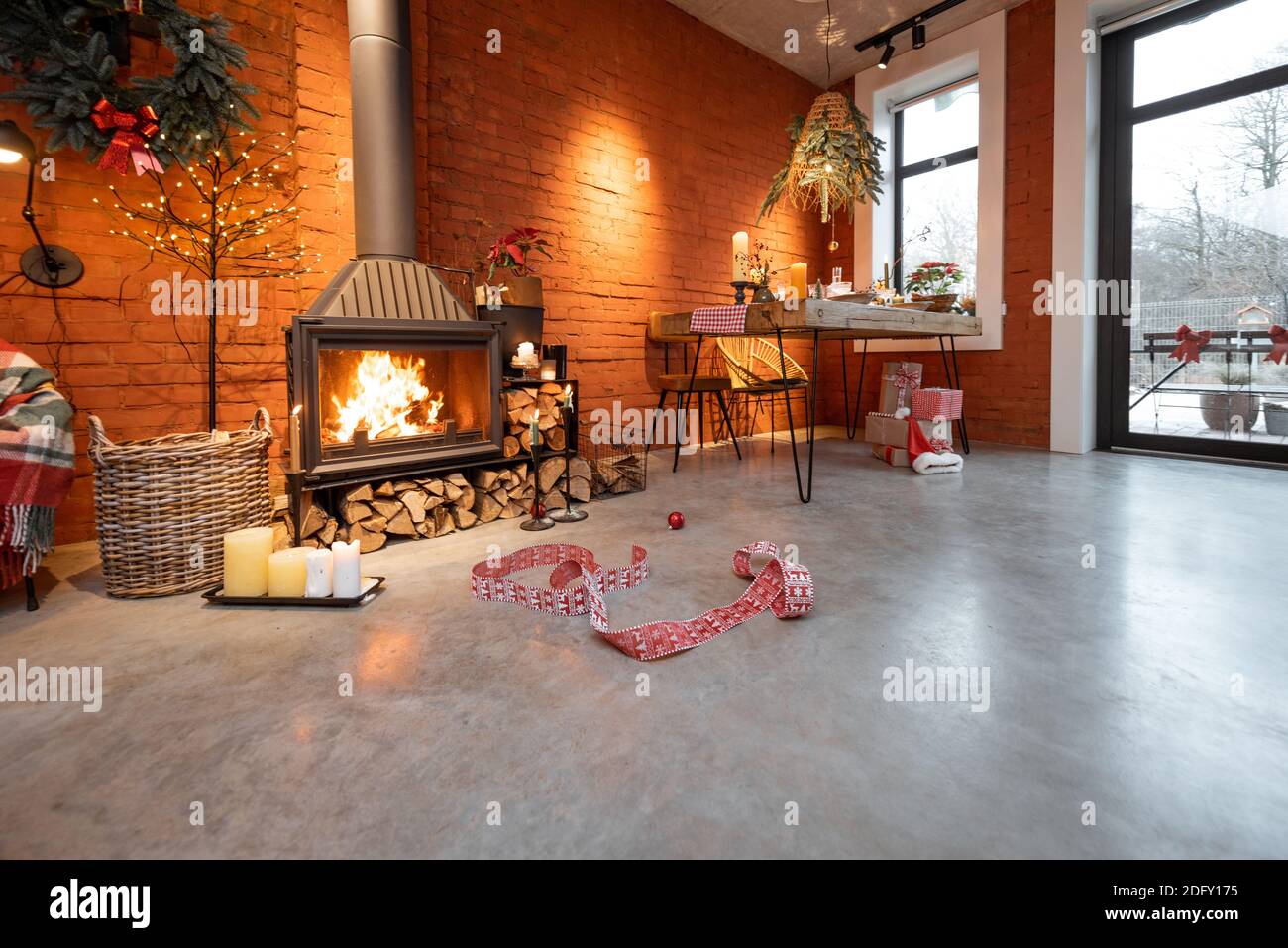 Kamin Bereich eines wunderschönen Loft-Stil Interieur mit echten Ziegel und Betonböden für die Neujahrsferien dekoriert. Das Konzept des Wohnkomforts Stockfoto