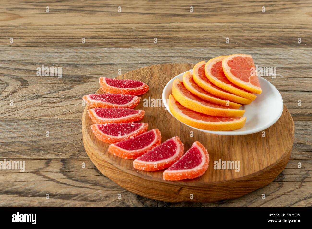 Zitrusgelee Scheiben in Zucker. Marmelade Scheiben von Orangen und Grapefruits auf Schneidebrett. Stockfoto