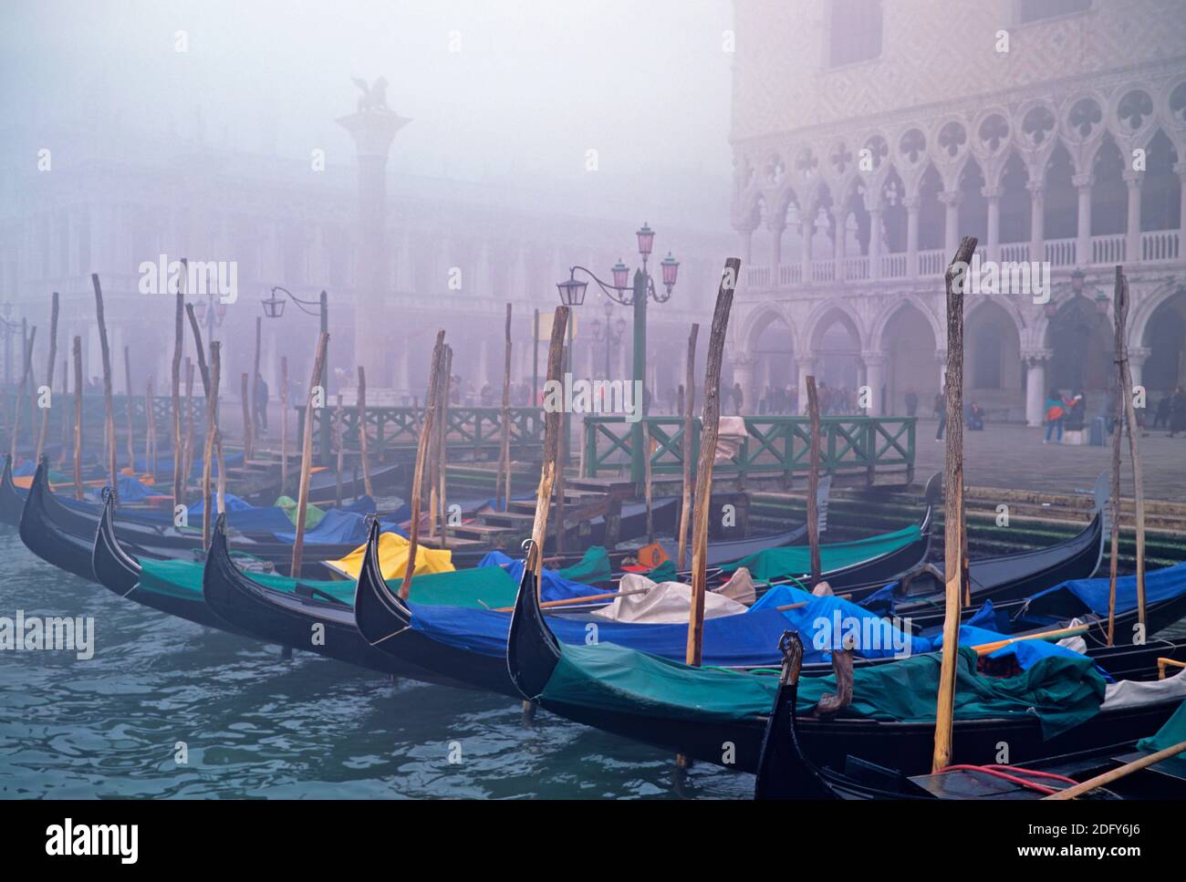 Venedig ein Blick über den Markusplatz über dem Ankerplatz Gondolos am Morgen Nebel auf ihren Anlegepfosten mit Vordergrundfokus Stockfoto