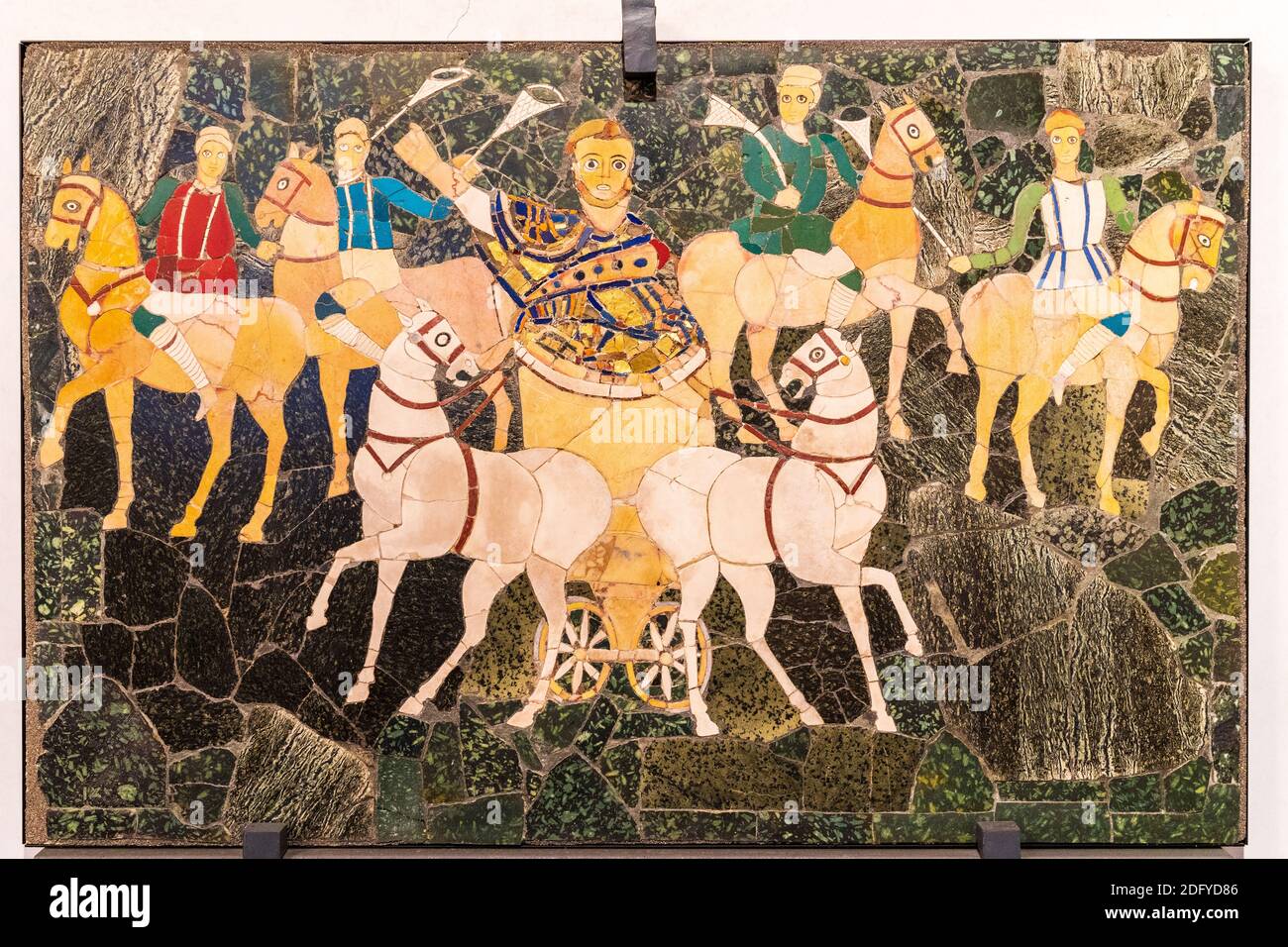 Tafel mit Marmor, Steinen und Perlmutt, die einen Wagen zeigt, der von einer Person der oberen Klasse angetrieben wird, gefolgt von 4 Reitern. Nationales Römisches Museum. Stockfoto