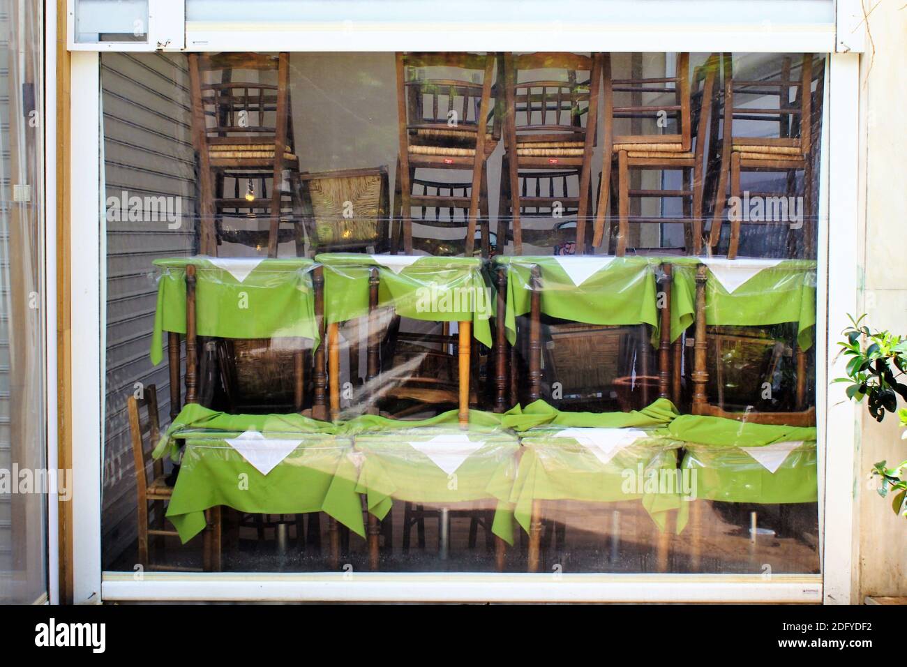 Athen, Griechenland, 6. Mai 2020 - Tische und Stühle stehen vor dem geschlossenen Café-Restaurant während der Coronavirus-Sperre. Stockfoto