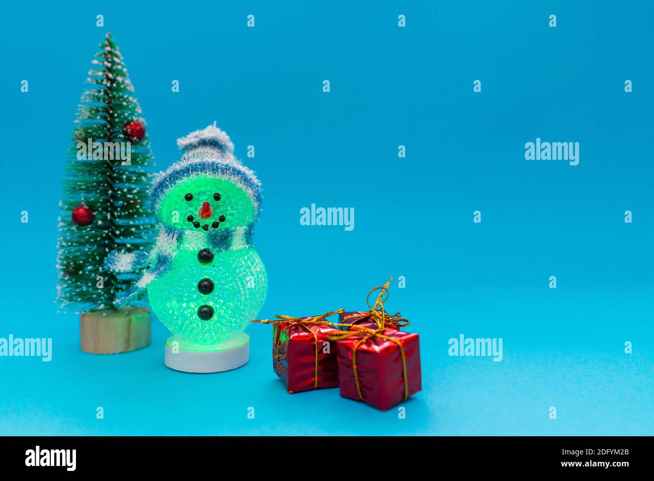 Leuchtet im dunklen Schneemann, Geschenke und Weihnachtsbaum mit Copy Space.Weihnachten und Neujahr Feier. Stockfoto