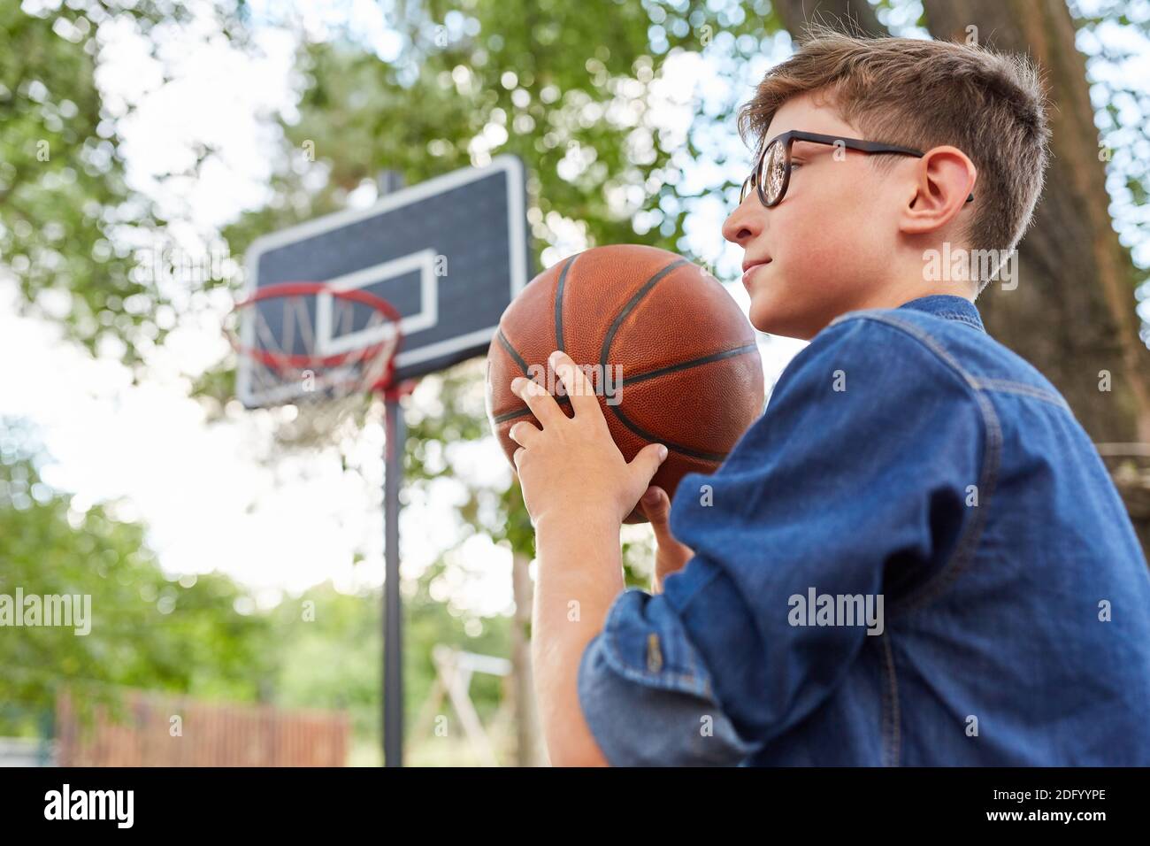 Junge spielt Basketball während des Trainings im Sommercamp oder Sommer Lager Stockfoto