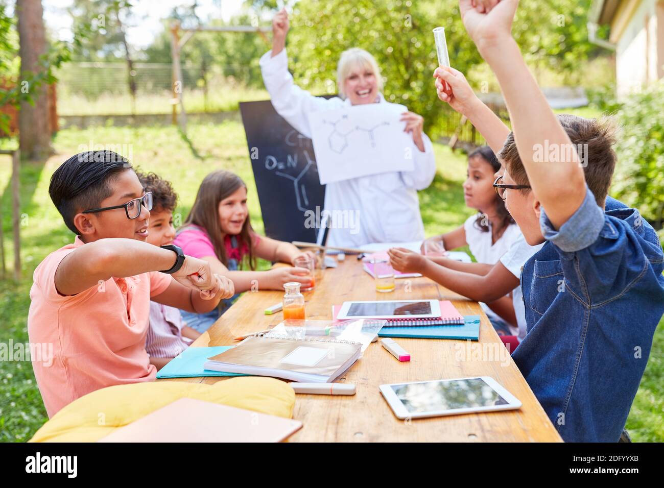 Die fröhliche Gruppe der Kinder und des Lehrers in der Sommerschule in Chemie-Klasse Stockfoto