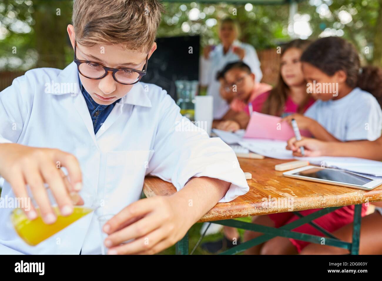 Ein Schüler in der Sommerschule Sommer Nachhilfekurs ist Ein Chemieexperiment durchführen Stockfoto