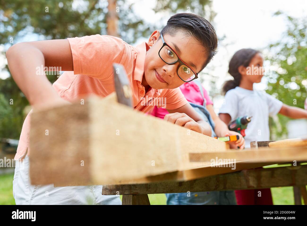 Boy hat Spaß mit Hammer und Holz im Urlaub zu arbeiten Lagerwerkstatt Stockfoto