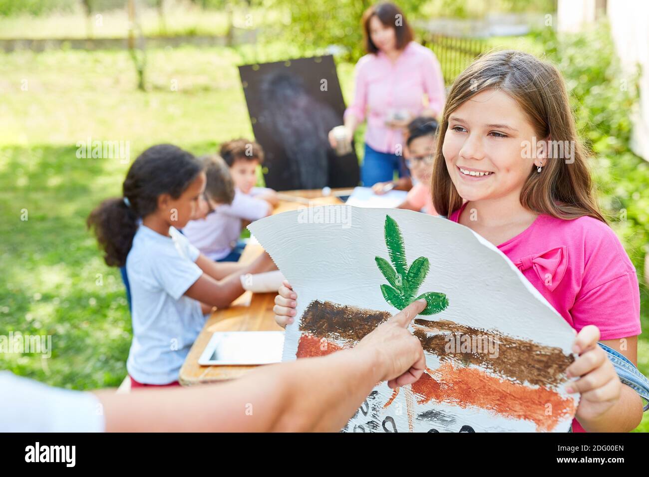 Mädchen im Sommercamp für Ökologie und Naturschutz mit Die Zeichnung einer Pflanze Stockfoto
