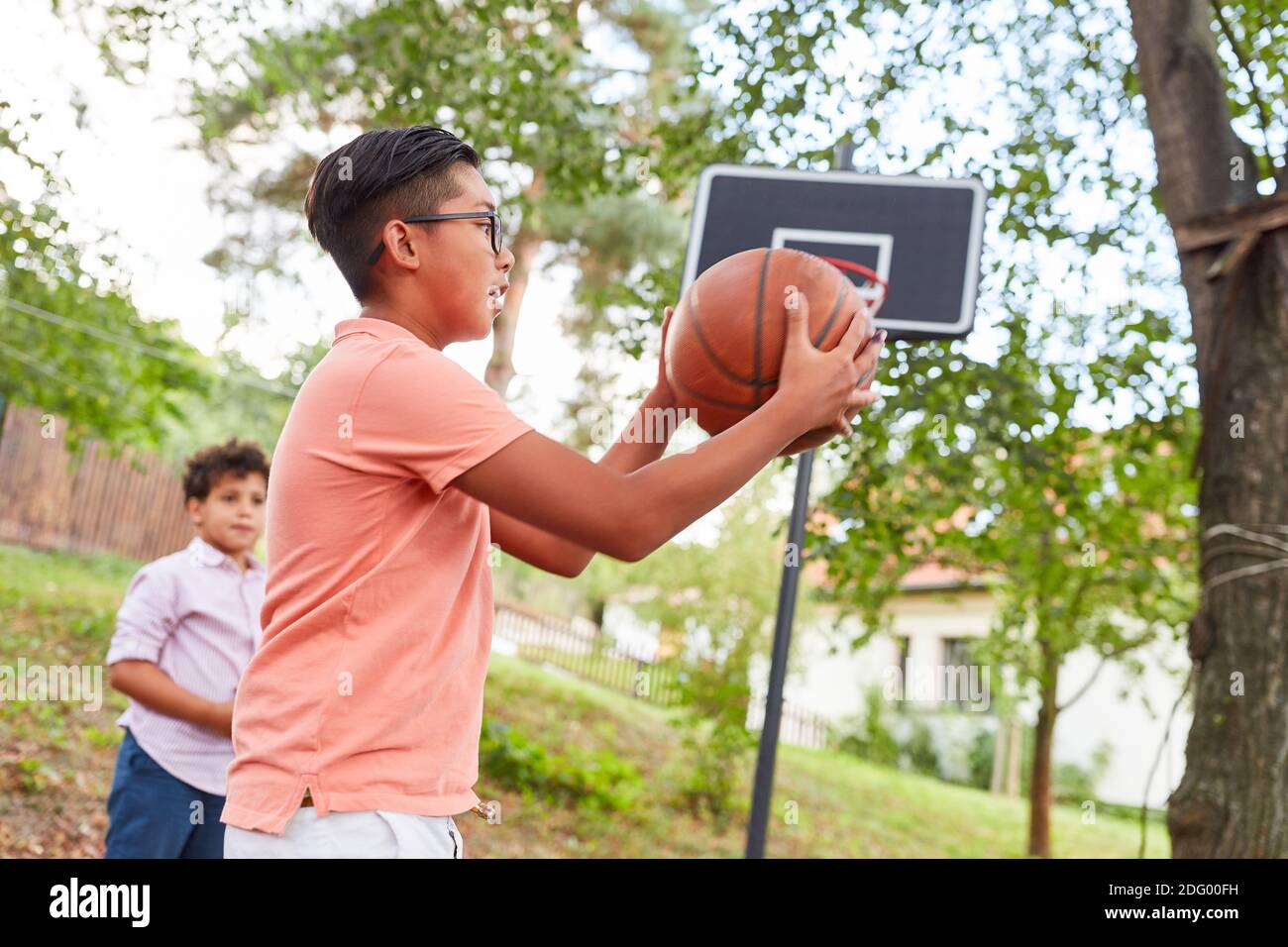 Kinder beim Basketballturnier im Sommercamp oder während Training vor dem Netz Stockfoto