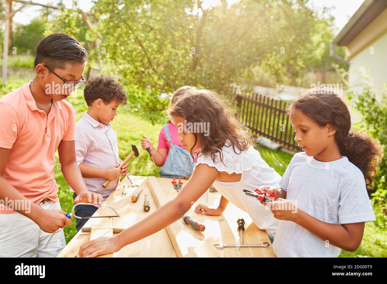 In der Handwerkerwerkstatt lernen die Kinder mit Holz zu arbeiten Im Sommercamp Stockfoto
