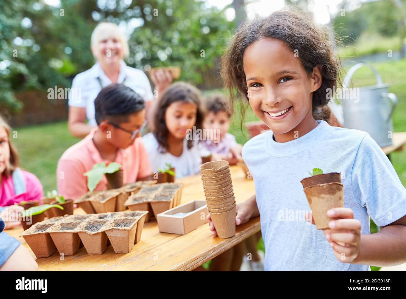 Kinder lernen in der Baumschule das Aussaat und die Vermehrung von Pflanzen kennen Oder im Ferienlager Stockfoto