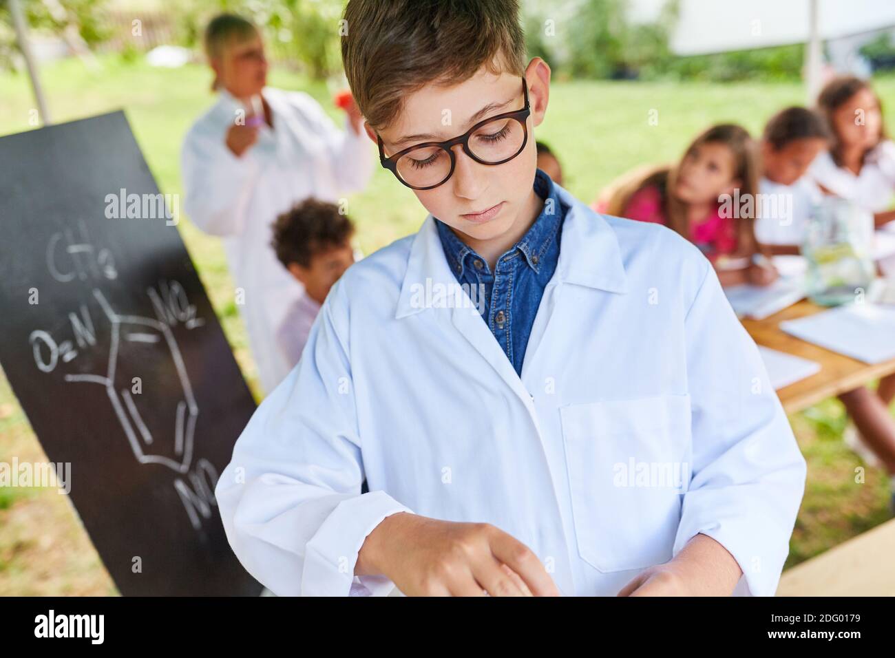 Junge in Chemie-Klasse im Sommer Schulferien Kurs tun Ein Experiment Stockfoto