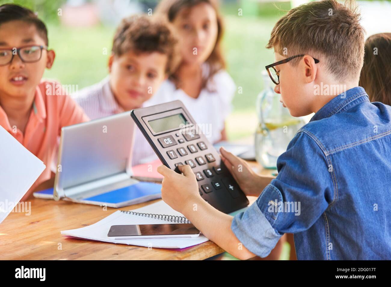 Kinder mit Taschenrechner lernen im Sommer Mathematik Nachhilfekurs Stockfoto