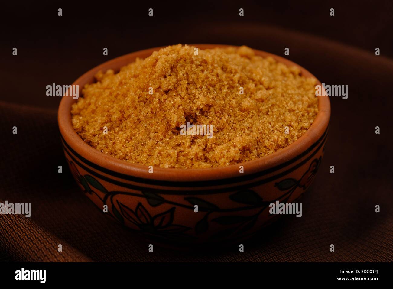 Brown Sugar Keramik Schüssel auf braunem Stoff Textur Hintergrund Stockfoto