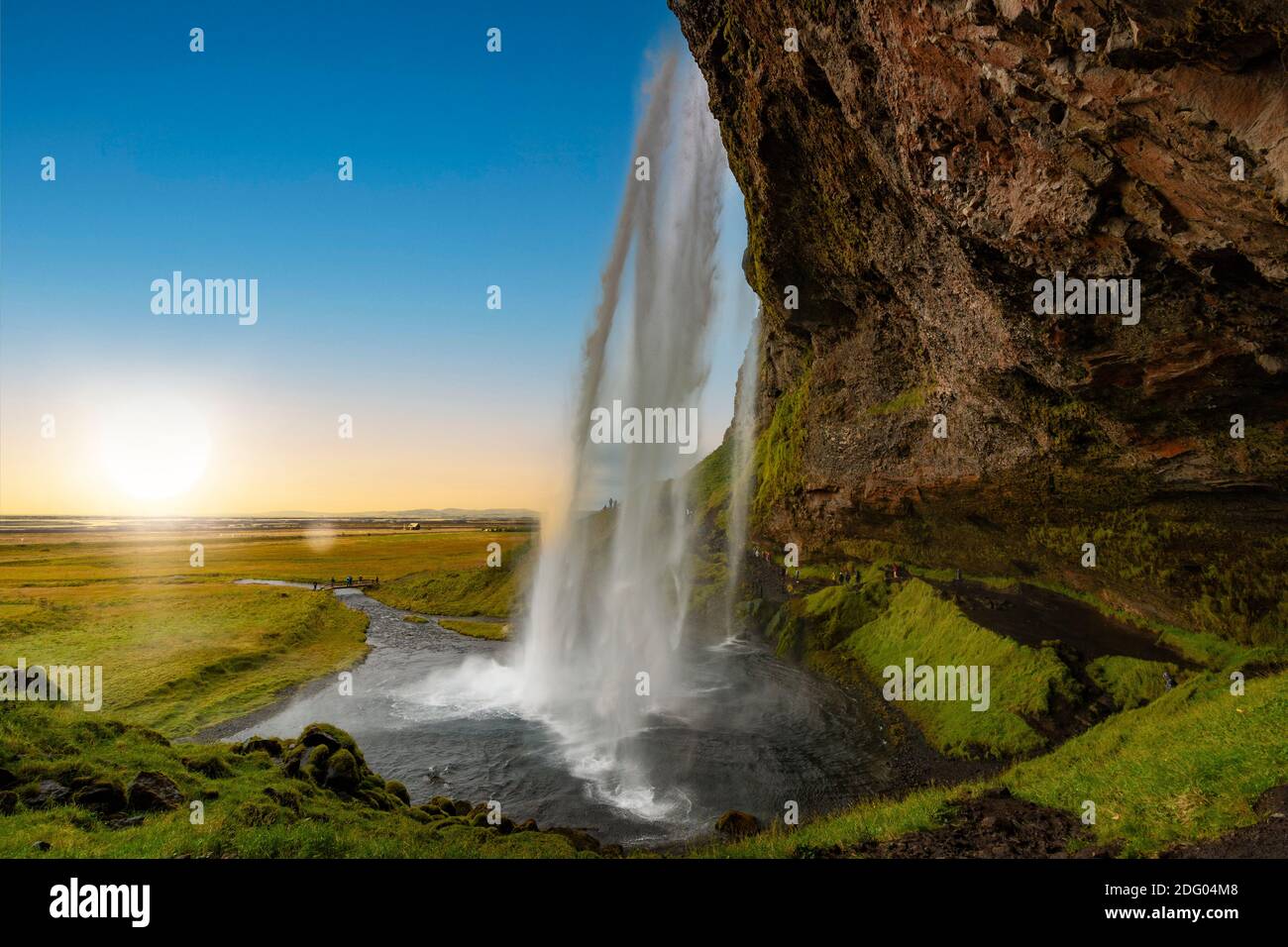 Blick durch den Seljalandsfoss Wasserfall in Island bei Sonnenuntergang Stockfoto