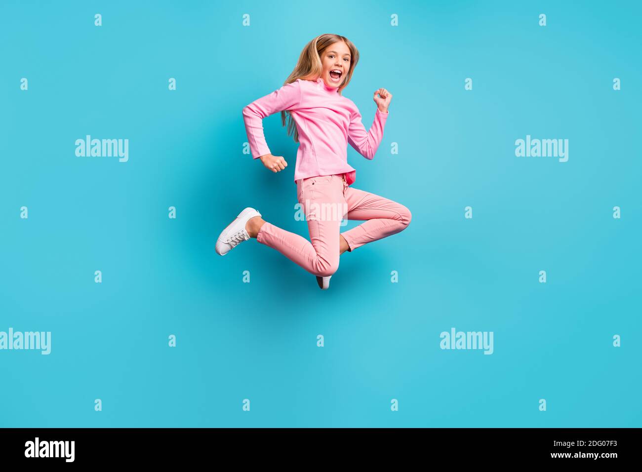 In voller Größe Foto von cool erstaunt ziemlich teen Mädchen springen Air tragen rosa Hose Poloneck weiß Schuhe auf hell isoliert blaugrün Hintergrund Stockfoto