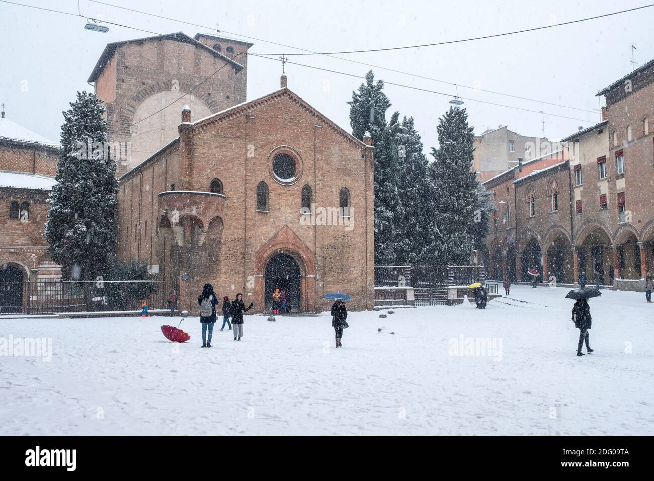 Menschen im Schnee vor der Basilika di Santo Stefano, Bologna, Italien. Stockfoto
