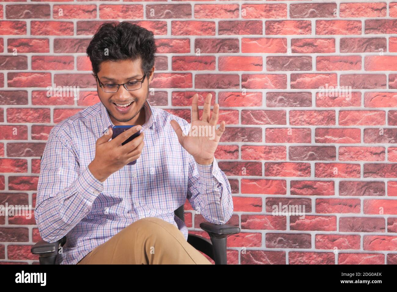 Glücklicher junger Mann in einer Videokonferenz über Smart diskutieren Telefon Stockfoto