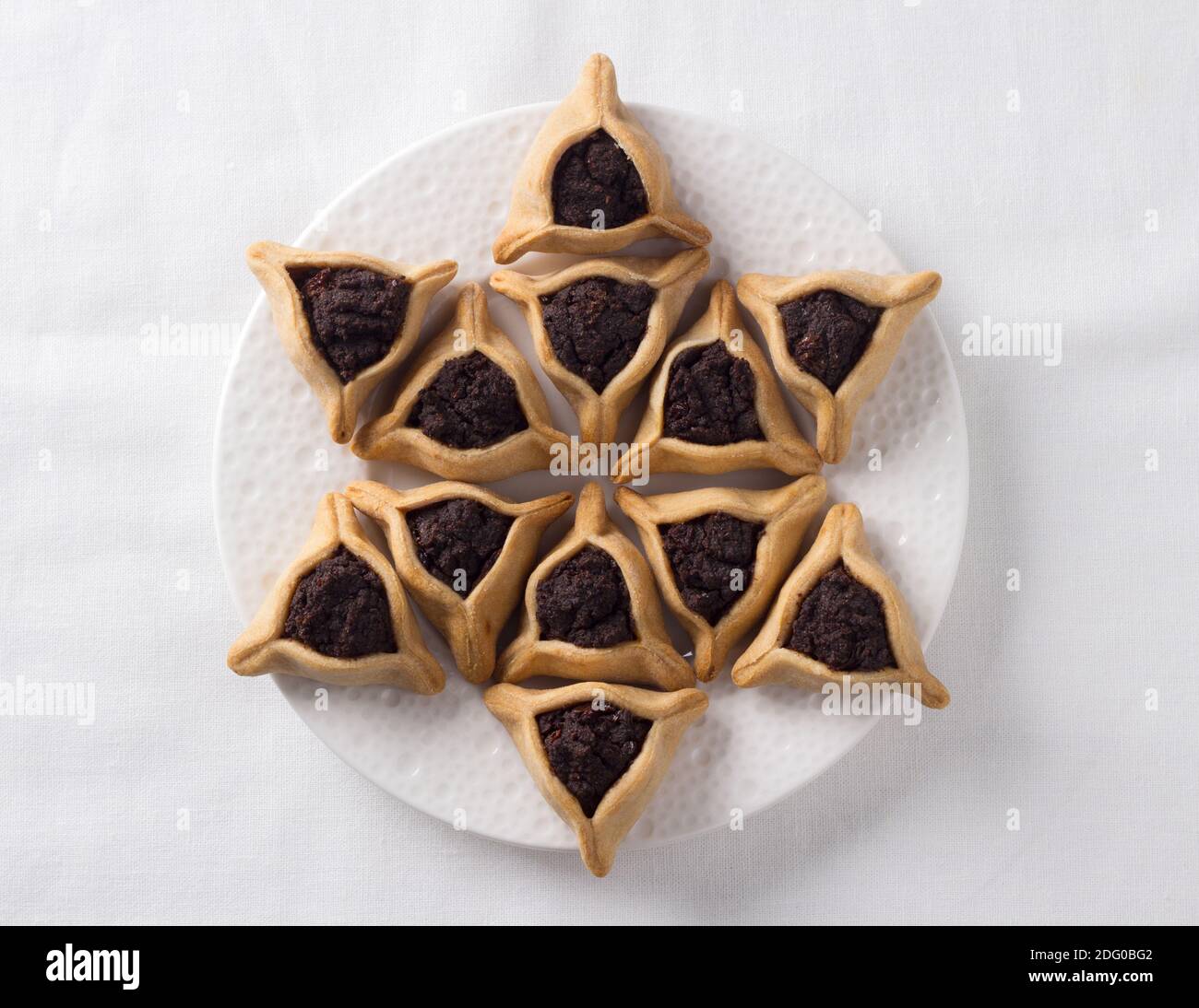 Traditionelle Süßigkeiten für den jüdischen Feiertag Purim. Hamantashen Kekse oder Aman Ohren, dreieckige Kekse mit Mohn Samen, Draufsicht, Freiraum Stockfoto