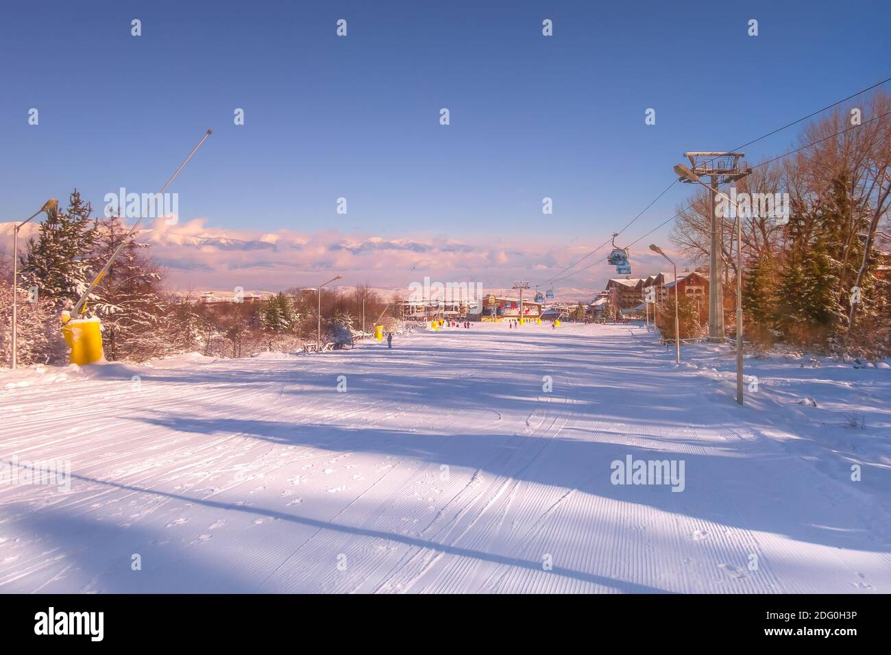 Bansko, Bulgarien - Januar 22, 2018: Winter Sonnenuntergang Skigebiet Bansko mit Skipiste, Gondelbahn Kabinen, Menschen und Berge Stockfoto