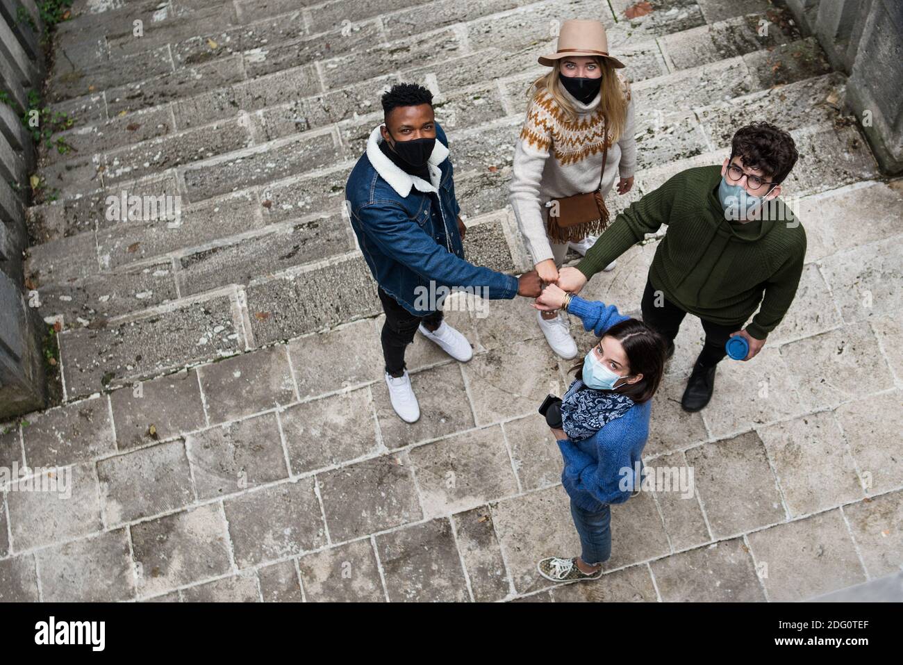 Draufsicht auf Gruppe junger Leute, die draußen in der Stadt grüßen. Coronavirus-Konzept. Stockfoto