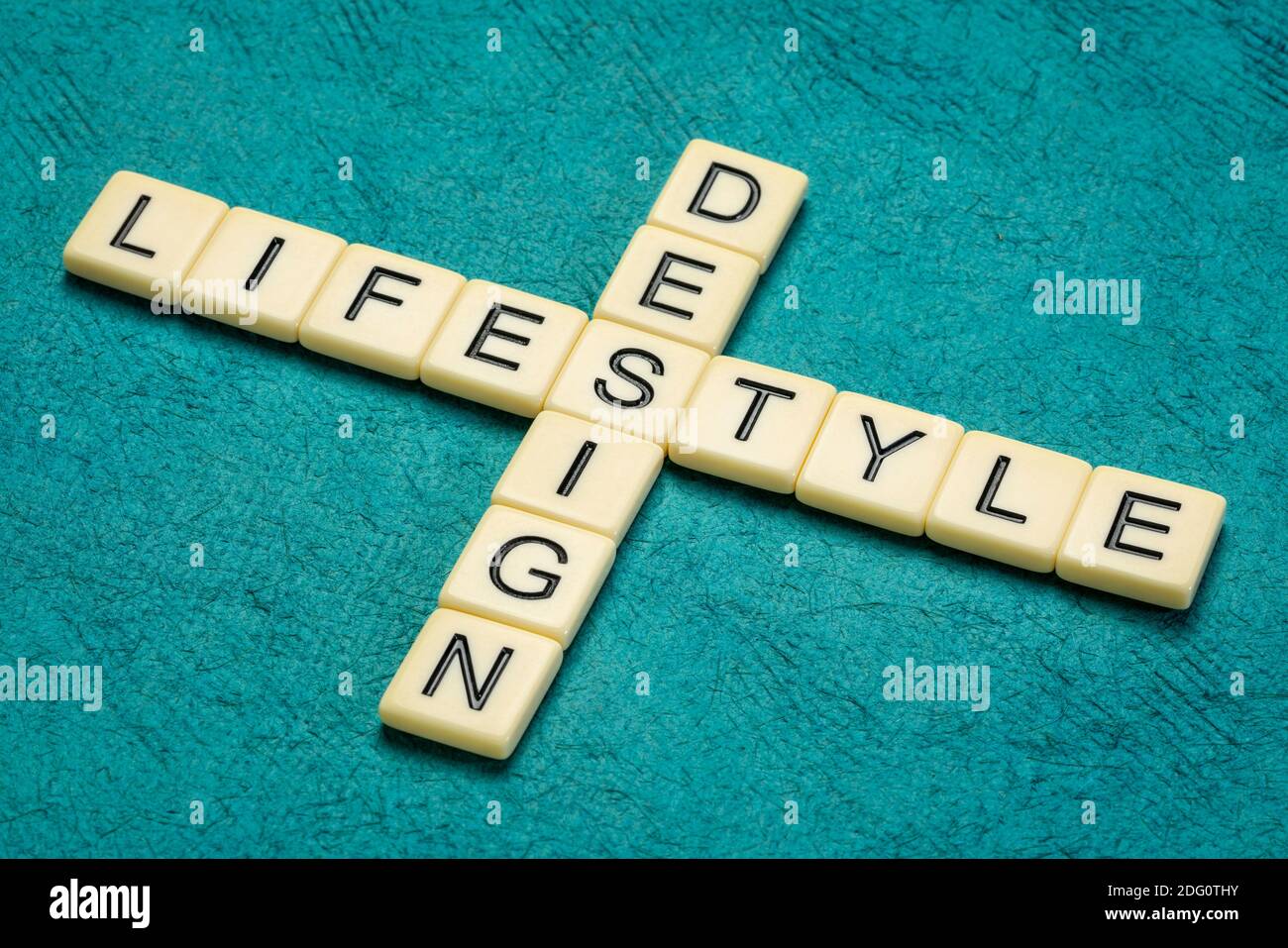 Design Lifestyle Kreuzworträtsel in Elfenbein Buchstaben Fliesen gegen strukturierte handgemachte Papier, persönliche Entwicklung Konzept Stockfoto