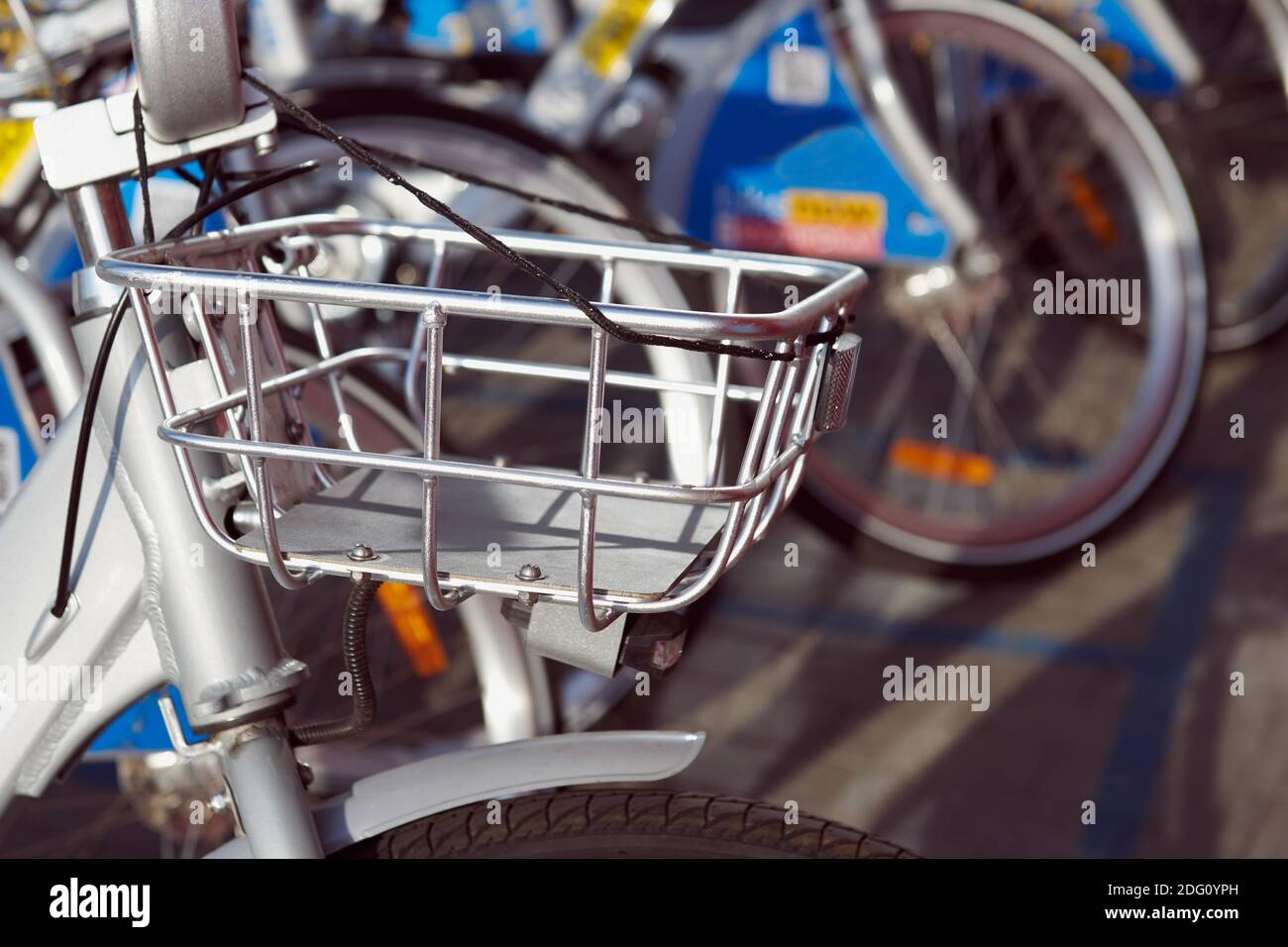 Fahrradverleih. Viele Fahrräder am Parkplatz. Vorderradkorb Nahaufnahme. Moderner Nahverkehr. Stockfoto