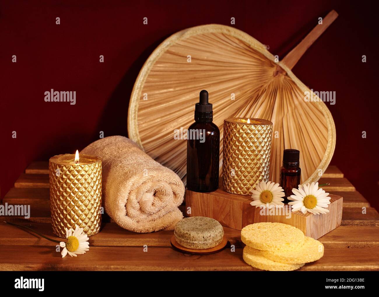 Wunderschöne Spa-Komposition. Aromatherapie mit Kräuteröl, Naturseife und Goldkerzen. Entspannungsfarbe und wärmende Handtücher auf Holzhintergrund Stockfoto